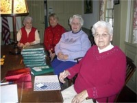 From left, Marjorie Deluse, Judy Grecco, Barbara Ford and Carolyn Richardson pose for a recent photo at the Stetson House in Hanover. In front of them is a stack of the historical society’s newly published genealogy book. Wicked Local photo by Ruth Thompson 