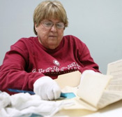 Janice Gilbert, a volunteer with the DeKalb Genealogical Society, packs up old records Tuesday to be moved to the former Veterans Affairs building in Fort Payne. Photo by Melissa Smith. 