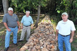 Larry Cornwell, front right, did much of the work to repair this rock wall surrounding the Middlebrooks Cemetery. Portions of the wall had been knocked down and buried. Also pictured are Underwod and New.