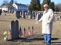 Cary Grant stands near the grave of one of the 52 Revolutionary War soldiers buried in the cemetery at Bethel Presbyterian Church. The church is in the background. Photo by Jennifer Becknell.