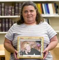 Joyce McGrath of Minneola poses with a picture of her sister, Linda Vott, on Thursday, April 21, 2011, in the Cooper Memorial Library's genealogical research room in Clermont. McGrath recently found Vott, whom she last saw as a young child in Ohio, withe the help of Sandra Oliver of Pastfinders, a genealogical research group that meets at the library.